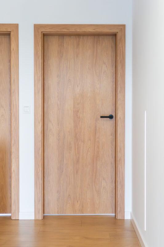 Drzwi wewnętrzne Porta gładkie w kolorze hikora naturalna z czarną klamką